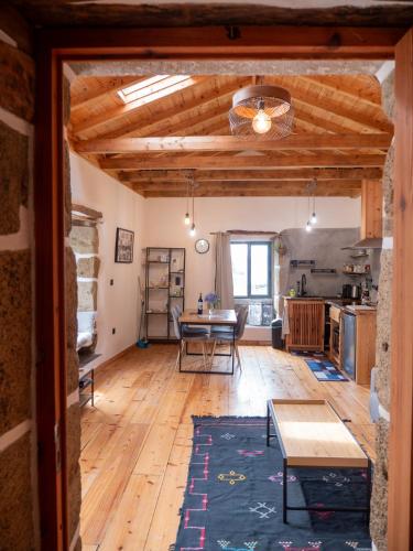 a living room with a table and a kitchen at Casa Azorina - Casas Florescer in Fajazinha