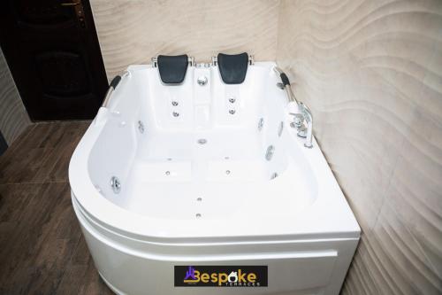 a white bath tub sitting in a bathroom at Bespoke Terraces in Benin City