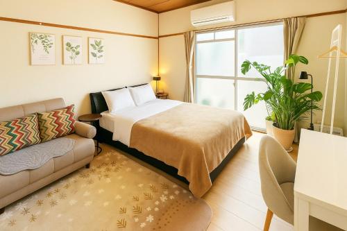 a hotel room with a bed and a couch at Minamimaekawa Heights Room 103 - Vacation STAY 93063v in Tokushima