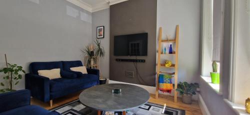 a living room with a blue couch and a table at Single Bed at Cozy Hailsham in London