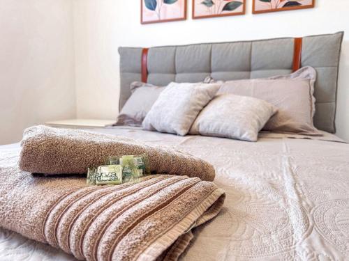 a bed with a blanket and pillows on it at Apartamento 1 quarto in Brusque