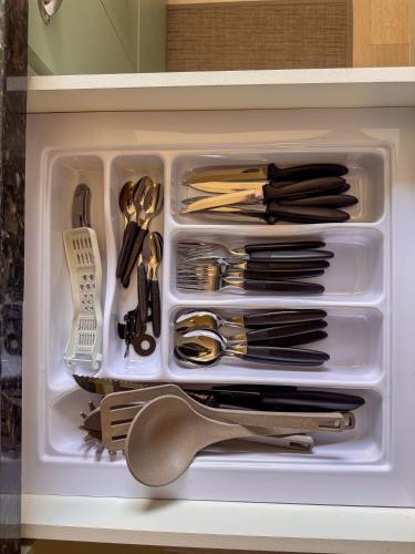 a white drawer filled with utensils in a drawer at Apartamento 1 quarto in Brusque