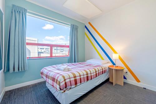 a small bedroom with a bed and a window at United Auckland in Auckland