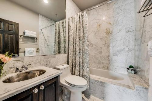 Un baño con inodoro, lavabo y bañera. en Enchanting 1br Retreat Tree-lined Swiss Ave, en Dallas