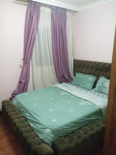 a bedroom with a bed with a green comforter at إثيوبيا أديس in Addis Ababa