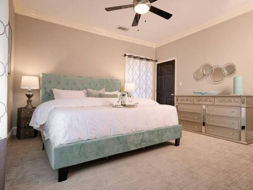 Un dormitorio con una cama grande y un ventilador de techo. en Enchanting 1br Retreat Tree-lined Swiss Ave, en Dallas