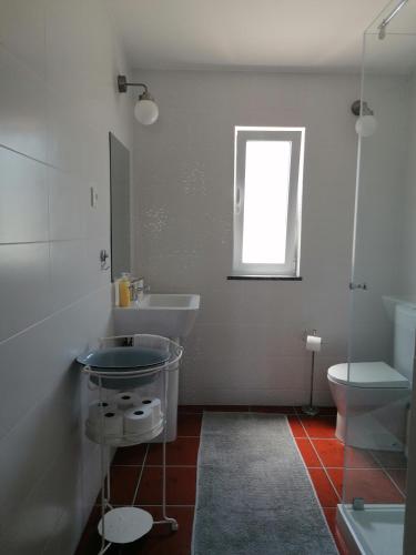 a bathroom with a sink and a toilet and a window at Monte Cores do Vale - Villa com piscina privada in Montemor-o-Novo