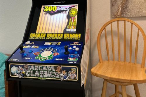 a pinball machine next to a wooden chair at Play Time in Waves