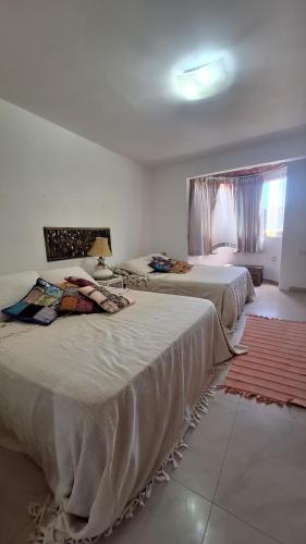 ein Schlafzimmer mit zwei Betten und einem Fenster in der Unterkunft Hermoso Apartamento vacacional in Porlamar