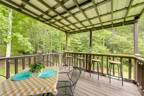 a deck with a table and chairs and trees at Hill Side Cosby Cozy Cove Cabin with Deck in Cosby