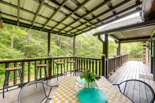 a porch with a table and chairs on a deck at Hill Side Cosby Cozy Cove Cabin with Deck in Cosby