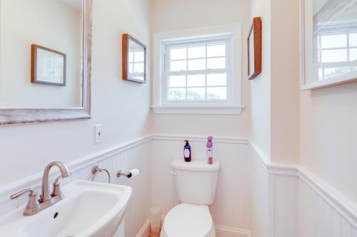 a white bathroom with a toilet and a sink at Walk to Pawcatuck River Family-Friendly Home! in Pawcatuck