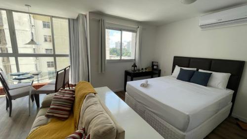 una camera da letto con un letto, un tavolo e un divano di Apto de luxo, requinte e lazer no coração de Belém a Belém