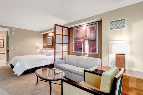 a hotel room with a bed and a couch and a table at Mgm 1 Bedroom Balcony And Or Studio Luxury Suites in Las Vegas