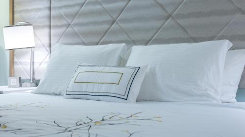 Una cama o camas en una habitación de New 2025-Ocean Sands Beach Boutique Inn-Sauna and Salt-Mineral Pool -Free Beach Bikes and Famous Beach-Nightly Popcorn-Bathrobes and Sunscreen in all rooms-Ultra Sparkling Certified-Free Laundry-4 Grand Presidential Black Beds in all rooms