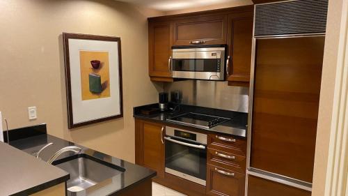 a kitchen with stainless steel appliances and wooden cabinets at Mgm 1 Bedroom Balcony And Or Studio Luxury Suites in Las Vegas