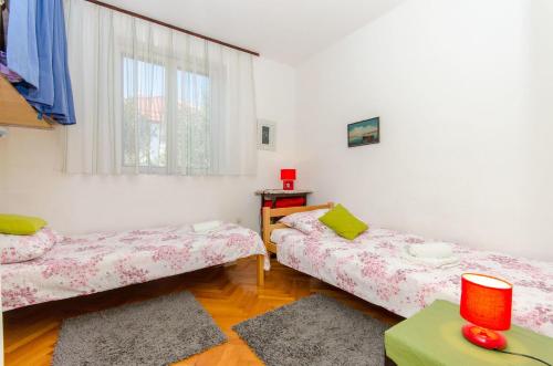 a room with two beds and a window at House Bojan in Supetar