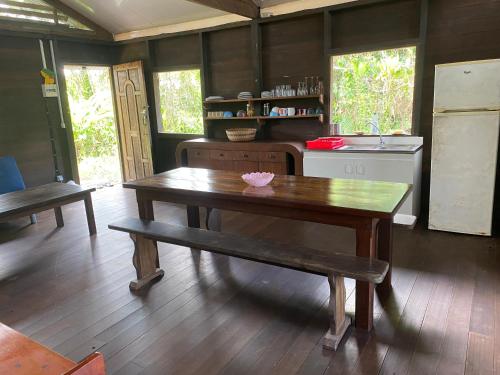 a kitchen with a wooden table and a bench at lakazatypique in Saint-Laurent du Maroni