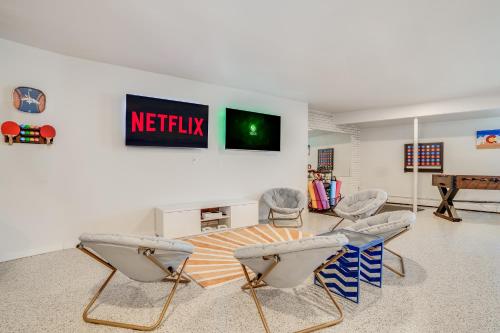 a living room with chairs and a table and a television at Mid-Century Escape 7 BR Sleeps 22 Hot Tub & Games in Westminster