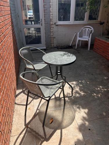 a table and chairs sitting on a patio at Vibrant Bungalow 2 Bedroom Flat with secure private parking in Birmingham