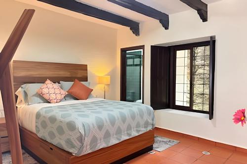 Un dormitorio con una cama y dos ventanas. en Diversión y bosque con amigos, en Villa Victoria