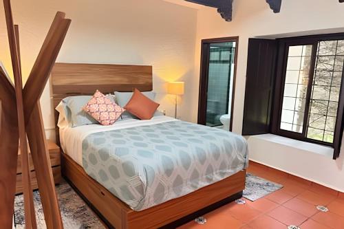 El HospitalにあるSuite romántica en Arboreaのベッドと2つの窓がある寝室