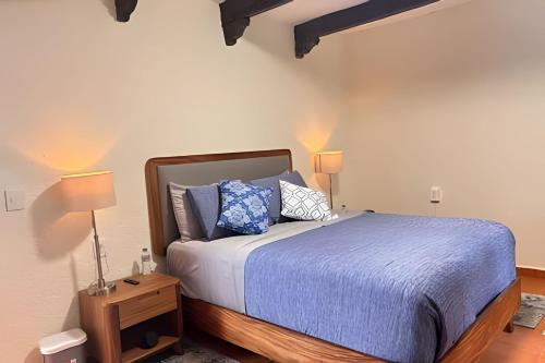 a bedroom with a bed with blue sheets and pillows at Refugio familiar en el bosque in Villa Victoria