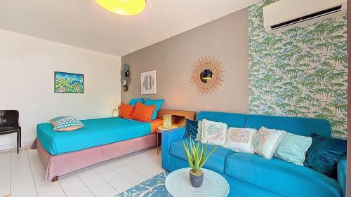 a living room with a blue couch and a table at PARADISIAC LAGOON in Saint-François