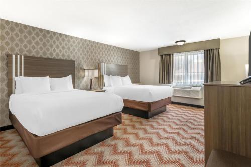 a hotel room with two beds and a television at Best Western Plus Sonora Oaks Hotel and Conference Center in Sonora