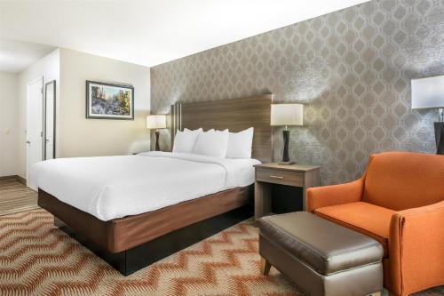 a hotel room with a bed and a chair at Best Western Plus Sonora Oaks Hotel and Conference Center in Sonora