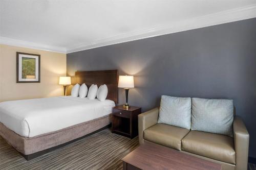 a hotel room with a bed and a couch at Best Western Augusta West in Augusta