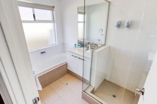 Un baño con ducha, bañera y lavabo. en Birdie Retreat, en Dunsborough