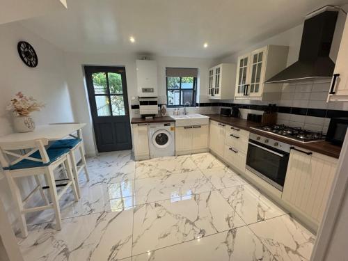 eine Küche mit Marmorboden und weißen Geräten in der Unterkunft Cozy Home In Headington, Oxford in Oxford