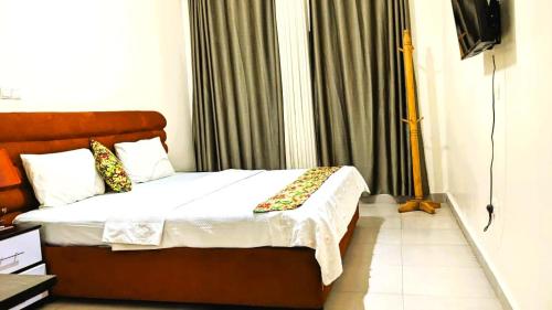 a bedroom with a bed and a window with curtains at Bati Valley Guest House in Kigali
