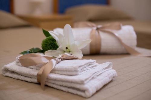 a pile of towels and a flower on a bed at A Due Passi Dall'Accademia in Florence