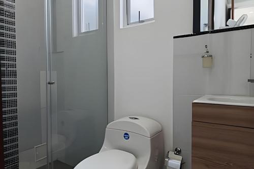 a white bathroom with a toilet and a sink at Reserva tu casa rodeada de naturaleza en Anapoima in La Mesa
