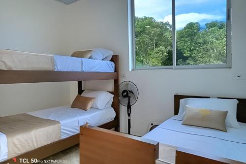 two bunk beds in a room with two windows at Reserva tu casa rodeada de naturaleza en Anapoima in La Mesa