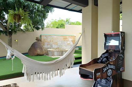 a room with a hammock and a tv at Reserva tu casa rodeada de naturaleza en Anapoima in La Mesa