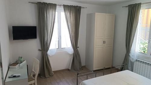 a bedroom with a bed and a window with curtains at LE GEMME Bed & Breakfast con parcheggio e giardino in Casarza Ligure