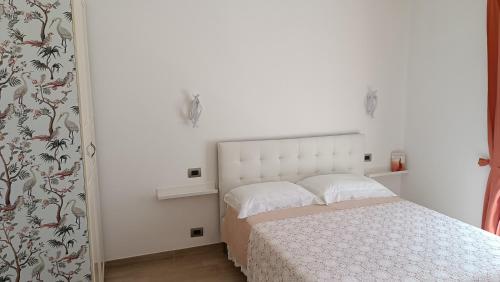 a bedroom with a bed with a white headboard at LE GEMME Bed & Breakfast con parcheggio e giardino in Casarza Ligure