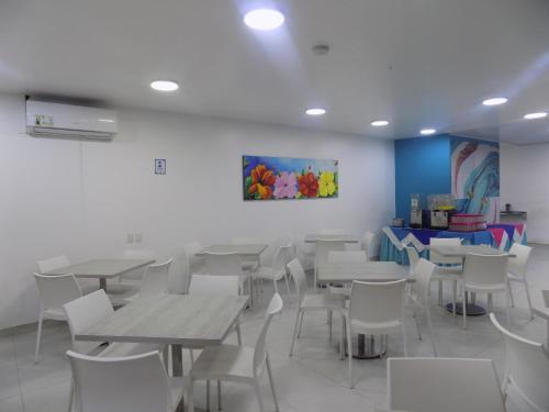 a dining room with white tables and white chairs at Hotel Verde Mar in San Andrés