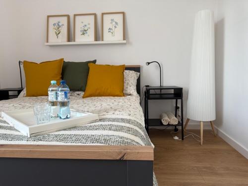 a bed with a tray with water bottles on it at Apartament Żabie Oczko in Zator