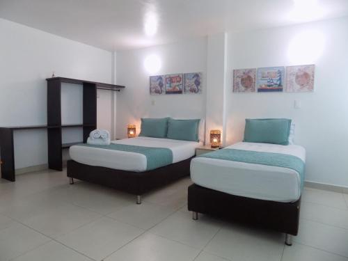 two beds in a room with two lamps on them at Hotel Verde Mar in San Andrés