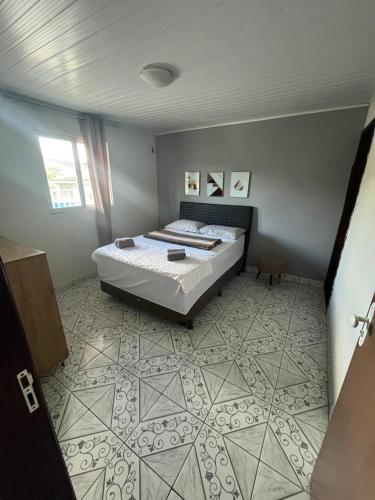 a bedroom with a bed and a tiled floor at Casa confortável com 3 quartos in Bonito