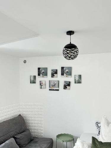 a living room with a couch and a pendant light at studio d'hote in Corbeil-Essonnes