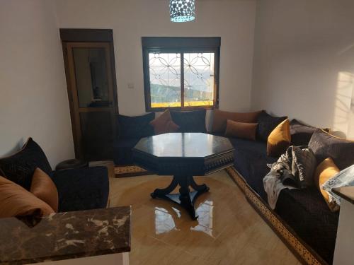 a living room with a couch and a coffee table at Maison campagne piscine ksar in Ksar es Sghir