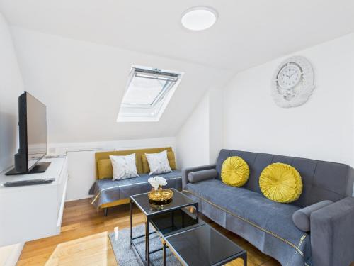 a living room with a blue couch and yellow pillows at Stylish 4BR North London Home by D3 Short Stay, Sleeps 9, Piccadilly Line in London
