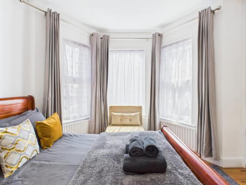 a bedroom with a bed with a pair of goggles on it at Stylish 4BR North London Home by D3 Short Stay, Sleeps 9, Piccadilly Line in London