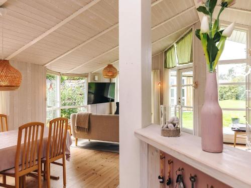 a dining room and living room with a vase on a table at 4 star holiday home in Græsted in Græsted