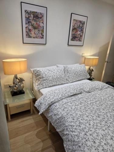 a bedroom with a bed and a table with two lamps at Hacienda - in Manchester
